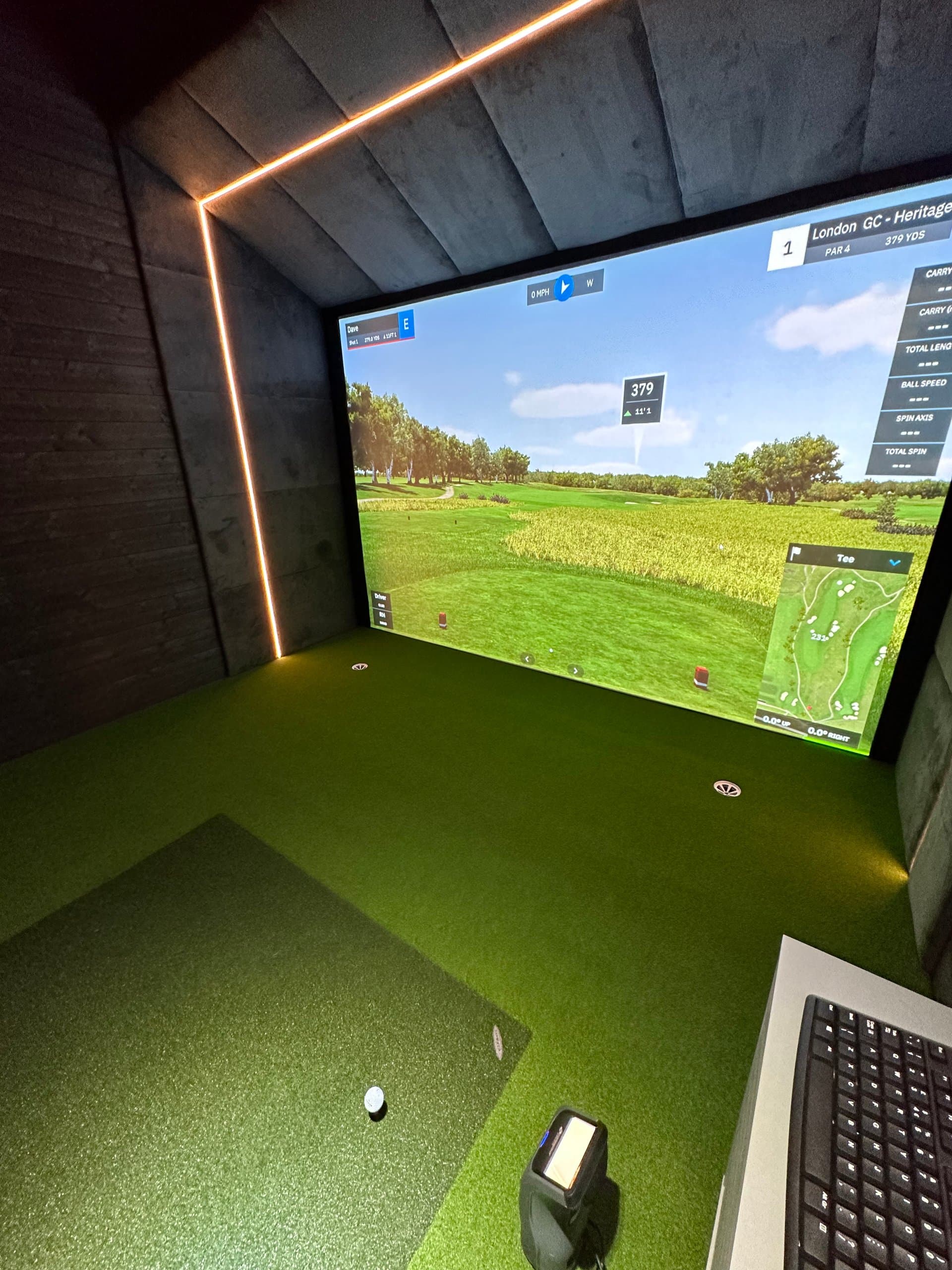 Course view on the simulator screen, with LED edging, a hitting mat and a keyboard in the corner