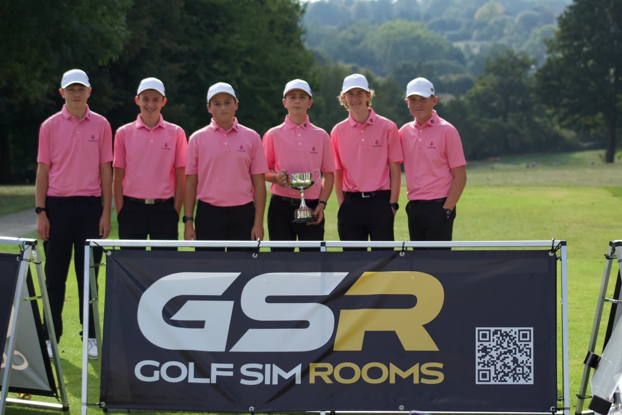 Tudor Park, the Cup winners, in pink with the cup behind the Golf Sim Rooms banner