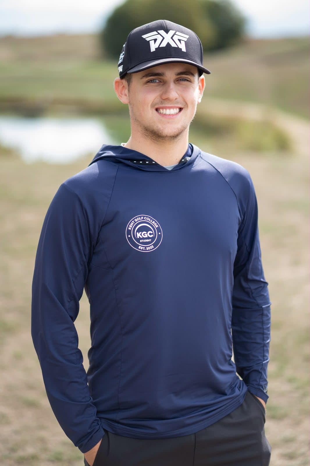 Joshua Mulley smiling on the course in a black cap