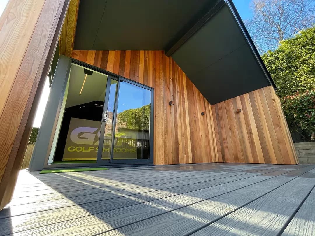 Cedar-clad garden room with a sliding glass door and the GSR logo visible inside