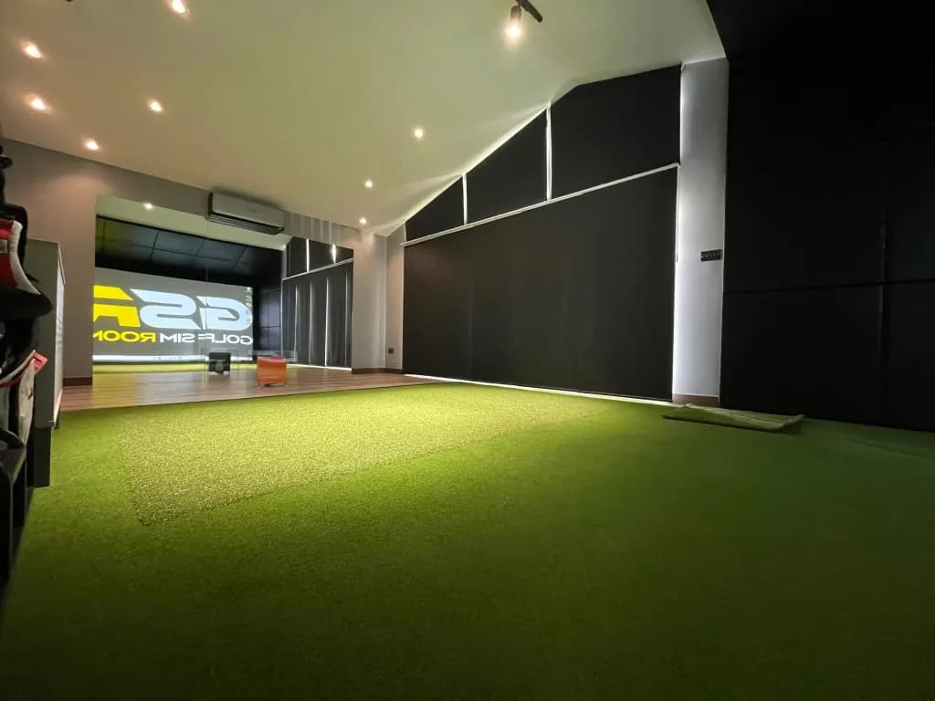 Turf floor running to the simulator screen, with dark panels along the wall