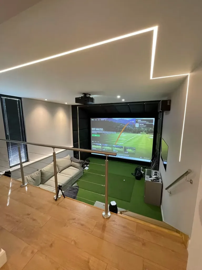 View down from the mezzanine over a glass rail to the simulator screen
