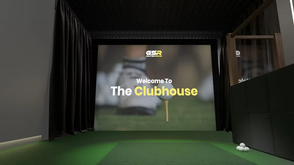 The Clubhouse's simulator screen between dark curtains, golf balls beside the hitting mat