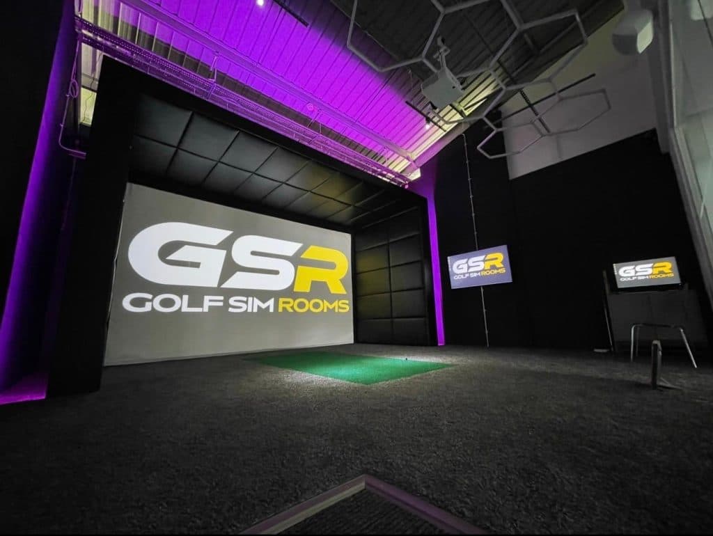 Large simulator bay under purple lighting in a warehouse-style space, with the GSR logo on the screen