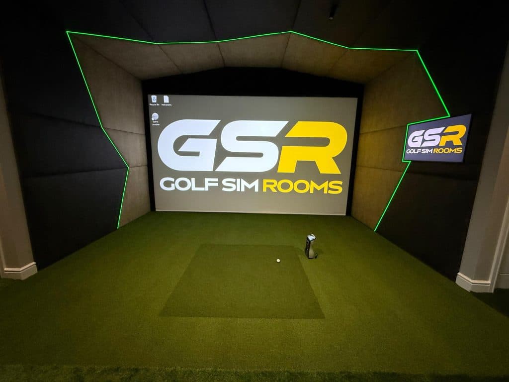 Simulator bay with the GSR logo on the screen, green LED edging round the padded surround and a hitting mat on the turf