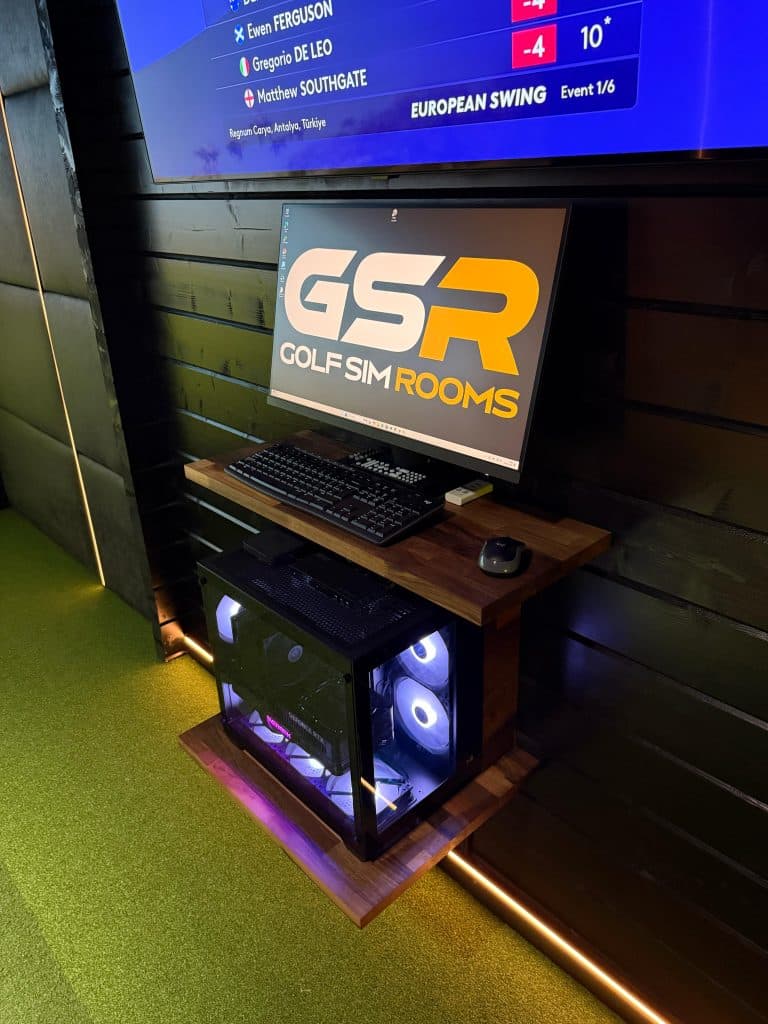 Gaming PC with coloured fans on a wooden shelf under a GSR-branded monitor