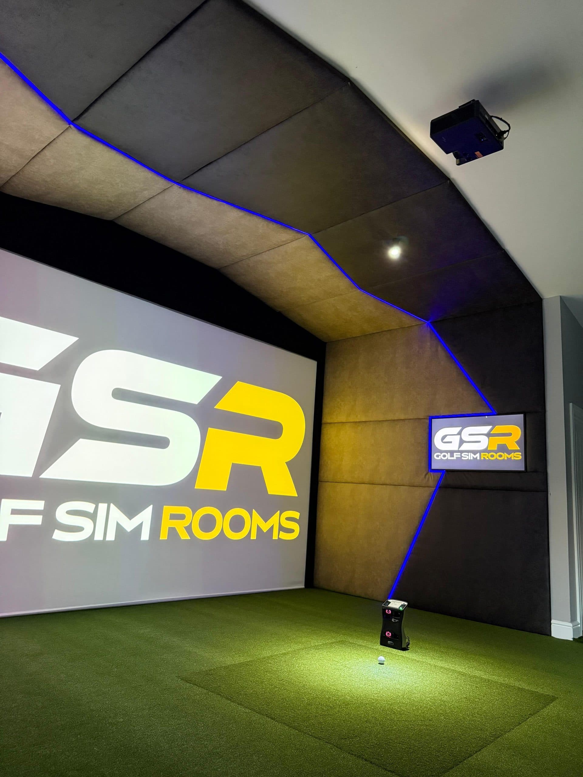 Simulator bay with blue LED edging and the Golf Sim Rooms logo on the screen